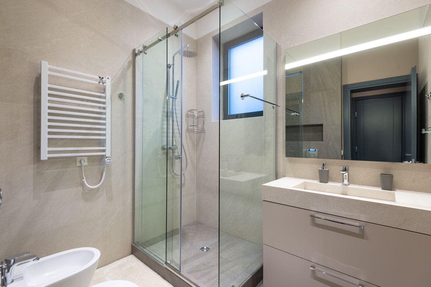 A finished bathroom with a spotless glass shower screen, clean vanity and polished mirror