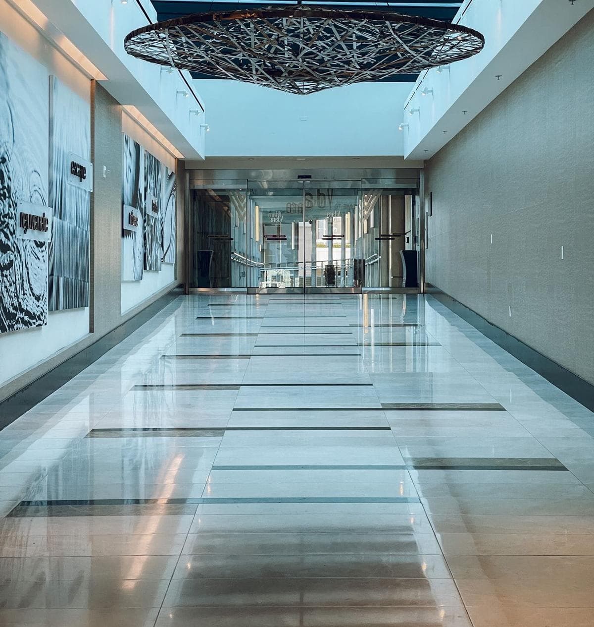 A commercial corridor with a polished, reflective floor running into the distance