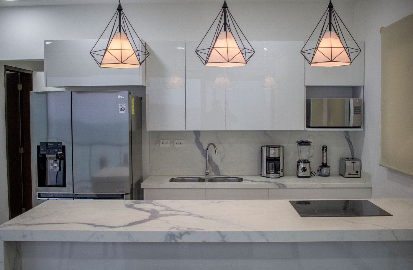 A modern kitchen with clear marble counter tops and clean cabinetry